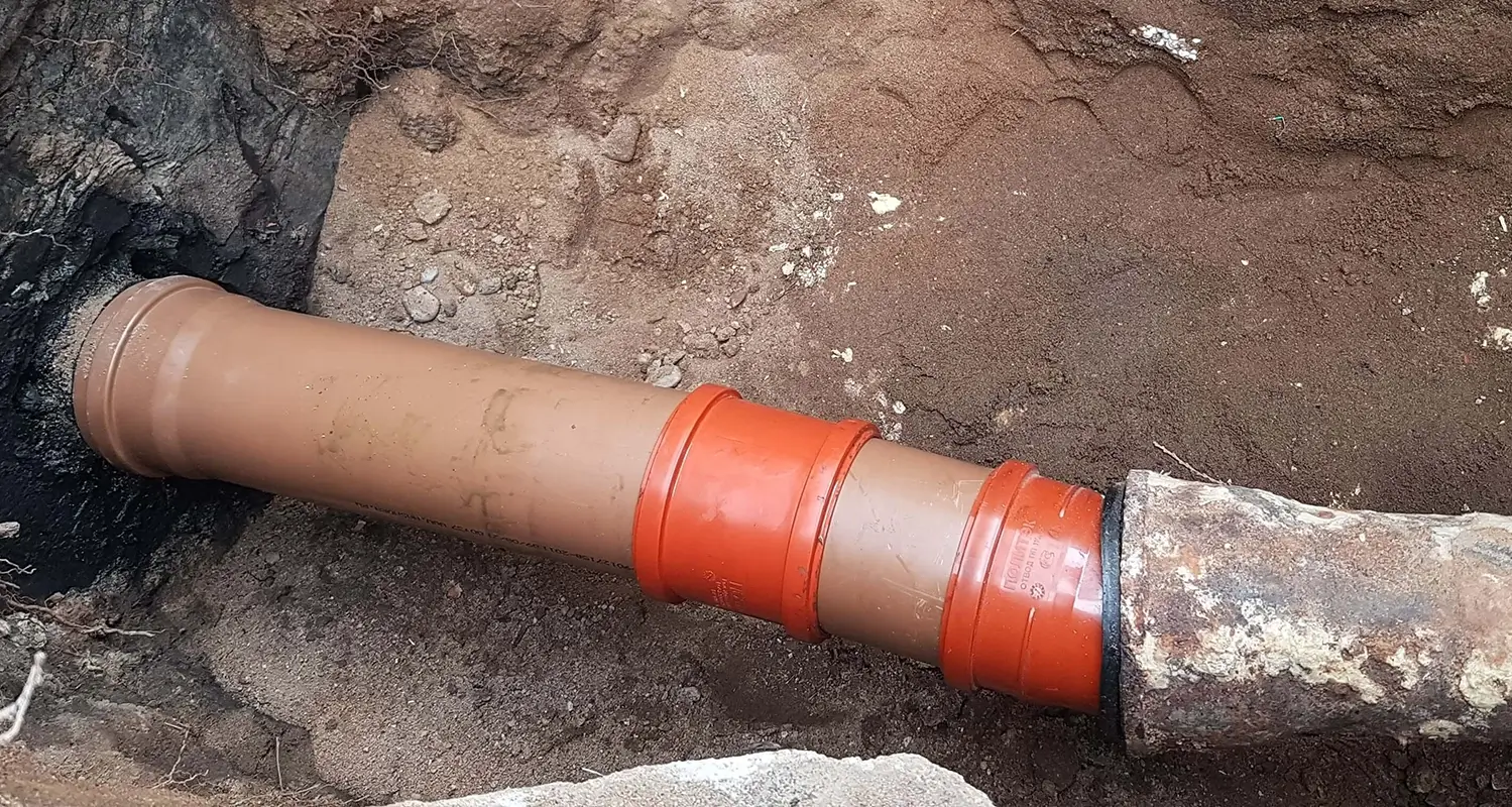 Large underground pipe in a trench that had to be dug out for a costly repair.