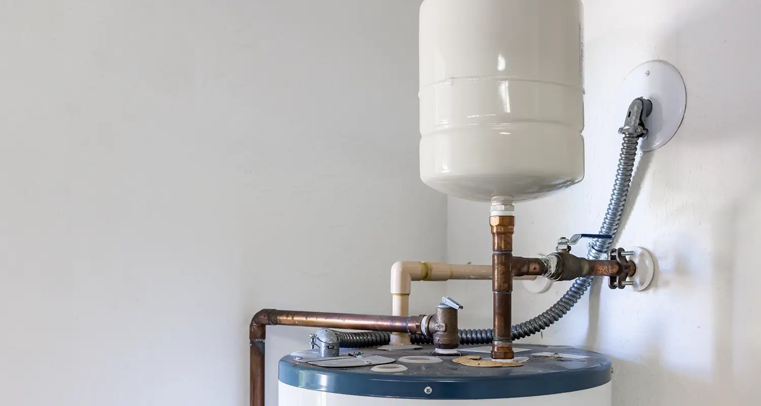 A water heater expansion tank attached to a water heater.